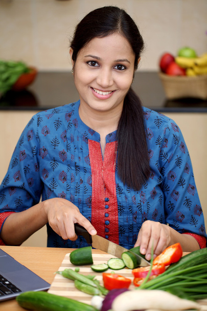 Gülümseyen genç Hintli kadın kesme sebze - Fotoğraf, Görsel