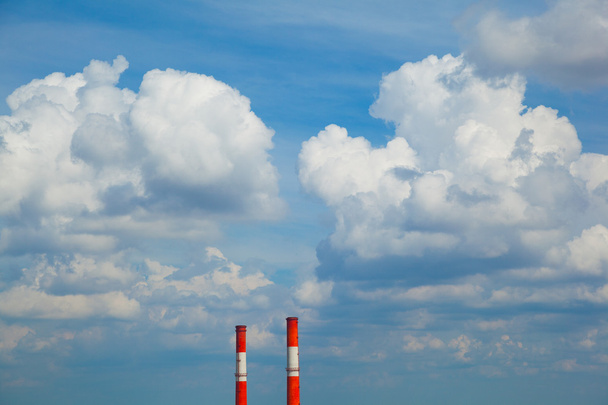Průmyslové potrubí na pozadí modré oblohy s mraky - Fotografie, Obrázek