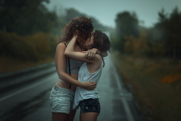 Chicas de pie bajo la lluvia en la calle
.  - Foto, imagen