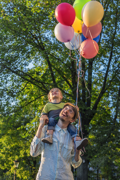 Отец и сын в парке с воздушными шарами
 - Фото, изображение