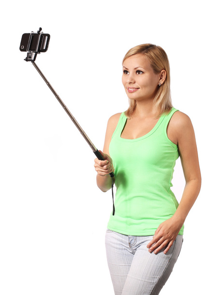 Young woman taking selfie photo with stick isolated on white - Fotó, kép