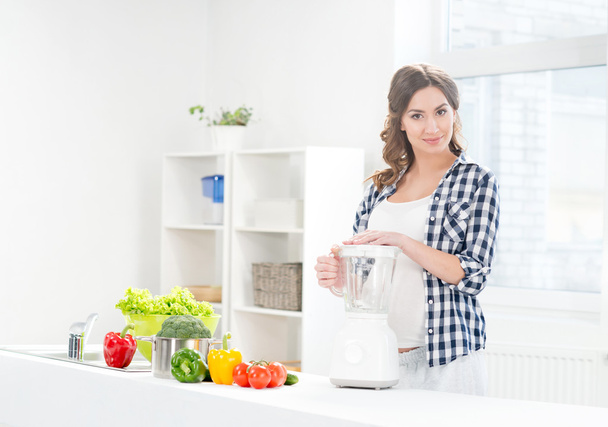 pregnant woman cooking with blender. - Photo, image