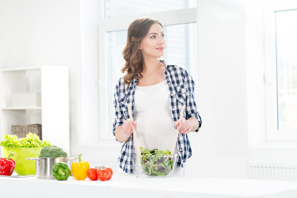 pregnant woman mixing salad - Photo, Image