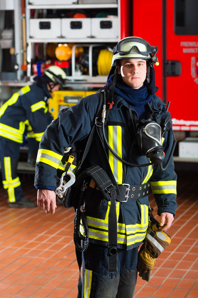young fireman in uniform in front of firetruck - Фото, зображення