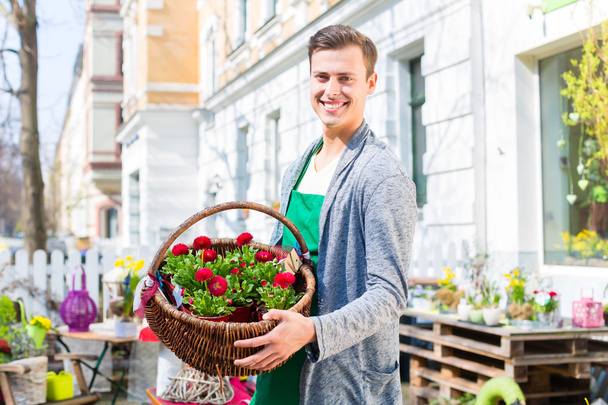 Florist with flower basket at shop selling - Foto, afbeelding