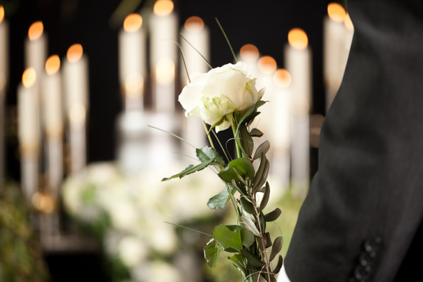 Grief - man with white roses at urn funeral - Photo, Image