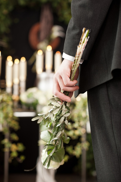 Verdriet - man met witte rozen op urn begrafenis - Foto, afbeelding