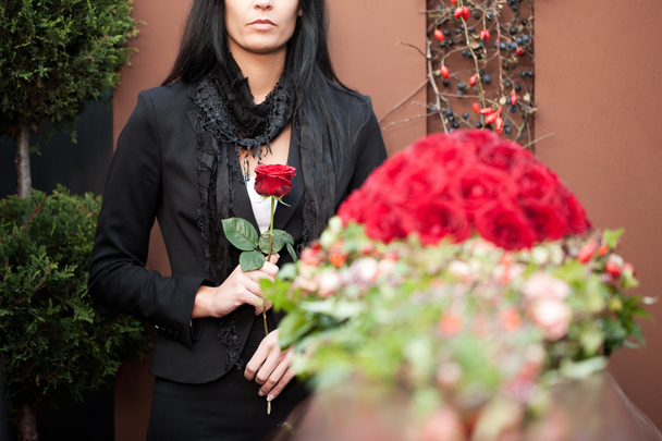 Mujer de luto en funeral con ataúd
 - Foto, Imagen