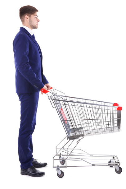 Young man with empty shopping cart - Fotó, kép