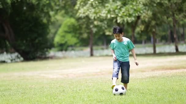 Young asian boy playing soccer in a park, Bangkok Thailand - Footage, Video