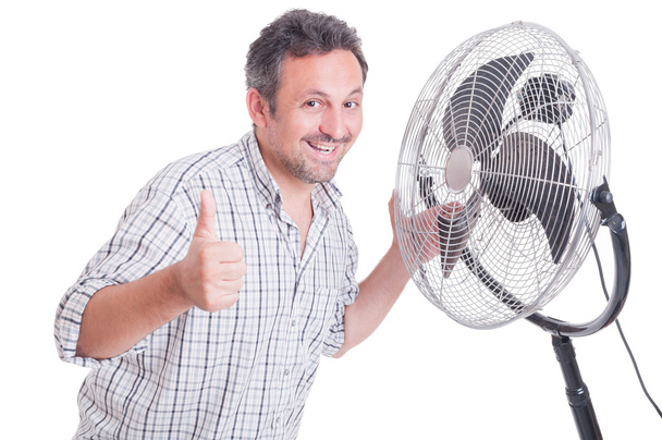 Smiling man showing like in front of blowing cooler - Photo, Image
