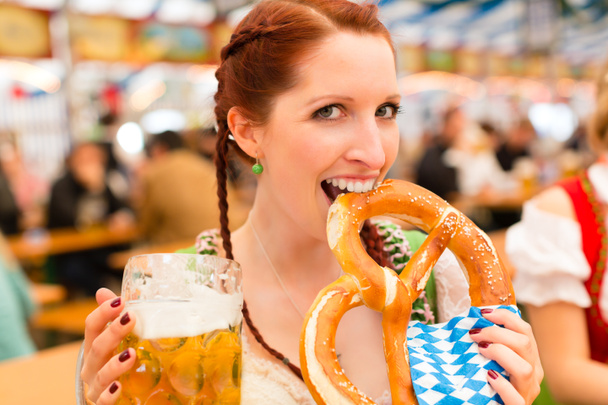 Woman with traditional Bavarian clothes in beer tent - Photo, Image