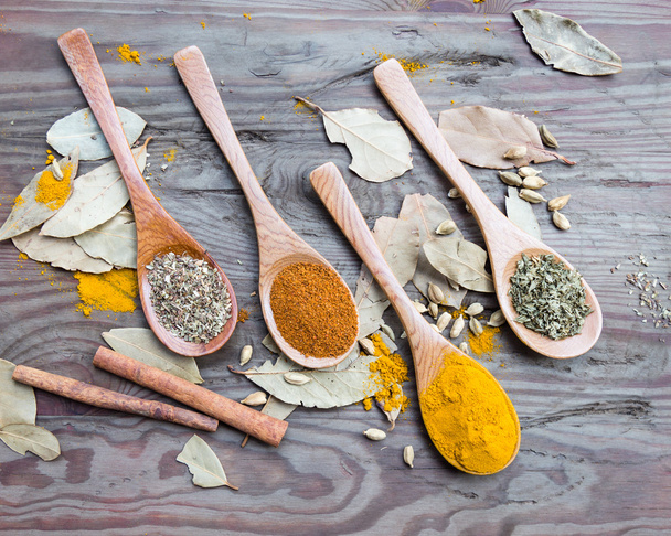 Spices in spoons on wooden table - Photo, Image