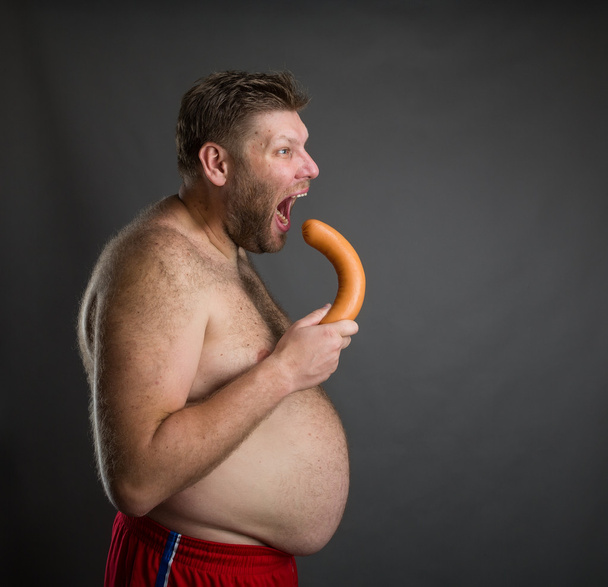 Hungry man with big sausage - Foto, afbeelding