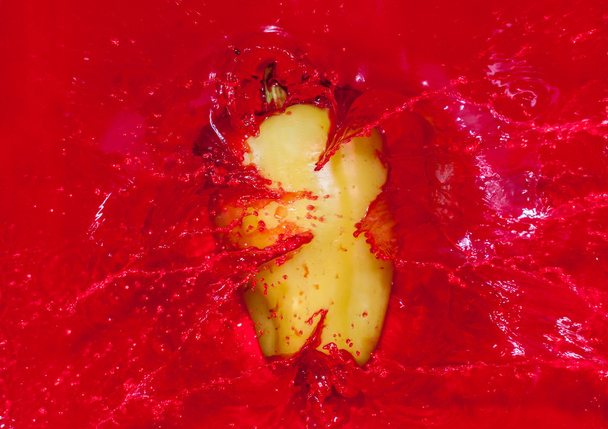 Green pepper in red water - Photo, Image