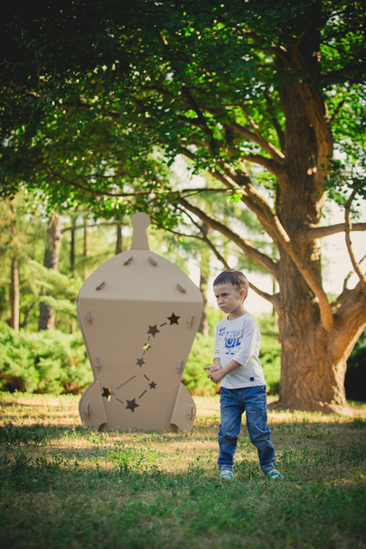 child playing in a cardboard spaceship. Eco concept - Φωτογραφία, εικόνα
