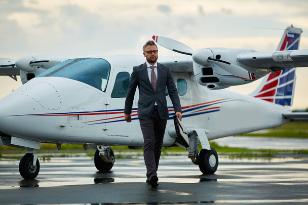 επιχειρηματίας με το χαρτοφύλακα με τα πόδια από το αεροπλάνο - Φωτογραφία, εικόνα
