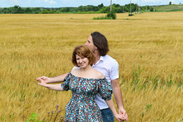 Loving middle-aged couple standing in field in summer - Fotoğraf, Görsel
