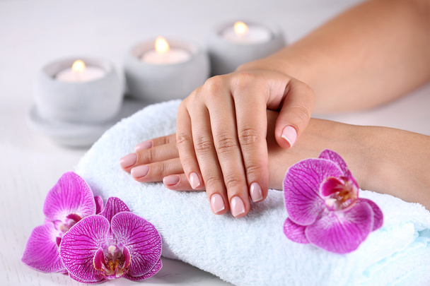 hands with french manicure and orchid flowers - Foto, imagen
