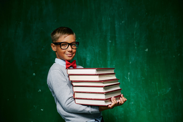 chico con pila de libros
 - Foto, Imagen