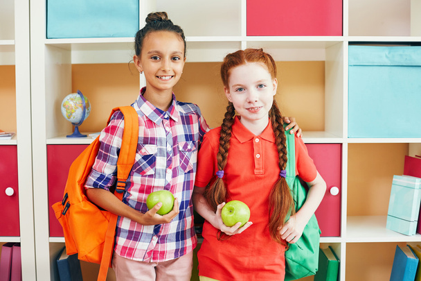 Mädchen mit grünen Äpfeln und Rucksäcken - Foto, Bild