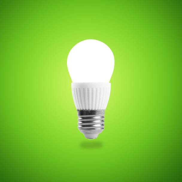 Світлодіодні лампи енергозбереження в руці на зеленому фоні
 - Фото, зображення