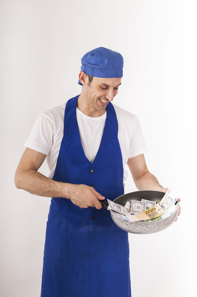 een chef-kok toont een pan vol met bankbiljetten - Foto, afbeelding