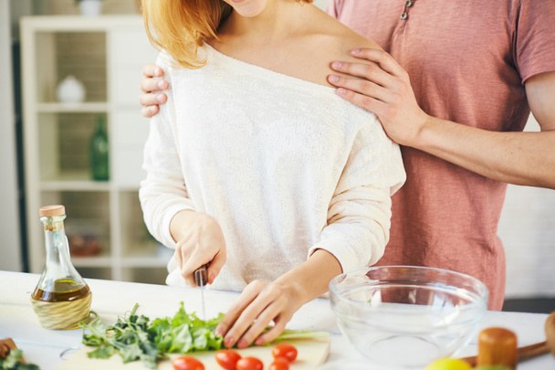 Frau schneidet mit ihrem Mann Salat - Foto, Bild