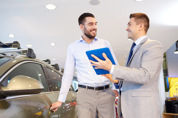 happy man with car dealer in auto show or salon - 写真・画像