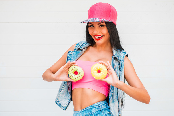 woman holding donuts against her breast - Фото, изображение