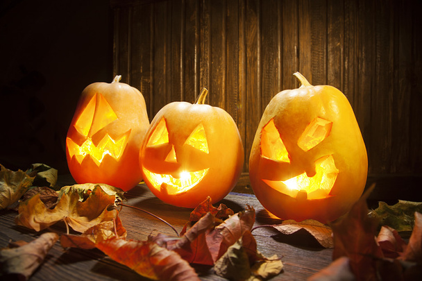 Jack o lanterns Halloween pumpkin face on wooden background - Фото, зображення