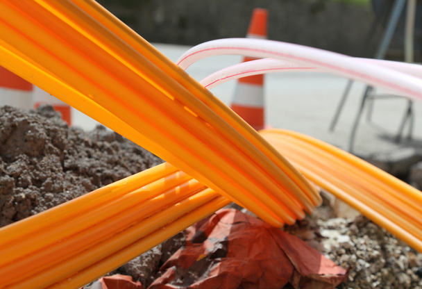 Oranje pijpen voor glasvezel in een grote stad wegenbouw  - Foto, afbeelding