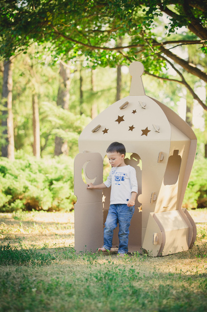 child playing in a cardboard spaceship. Eco concept - Фото, изображение
