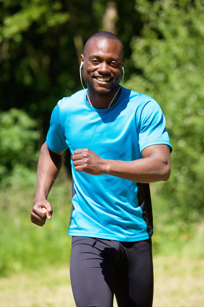 Happy smiling african american man running - Photo, Image