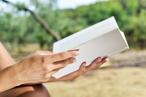 Молодая женщина читает книгу на открытом воздухе - Фото, изображение