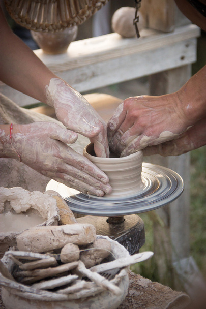 hands in the clay, four hands molded clay, the clay on a potter' - Zdjęcie, obraz