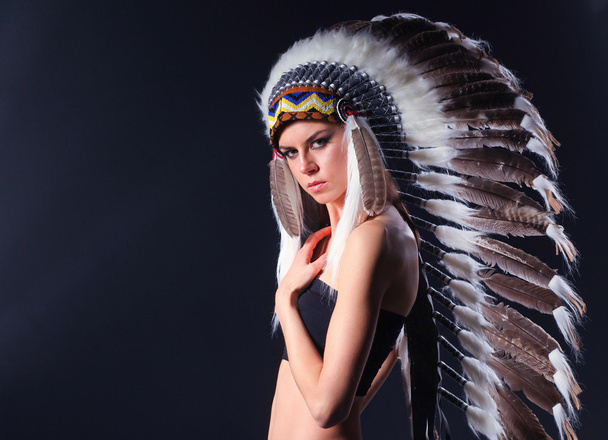 Beautiful woman in native american costume with feathers - Foto, afbeelding