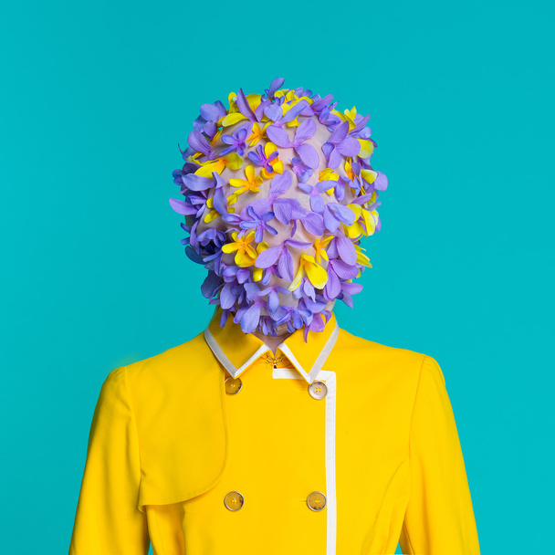 Modelo de moda en abrigo amarillo y accesorios de arte posando en el estudio sobre fondo azul
 - Foto, Imagen