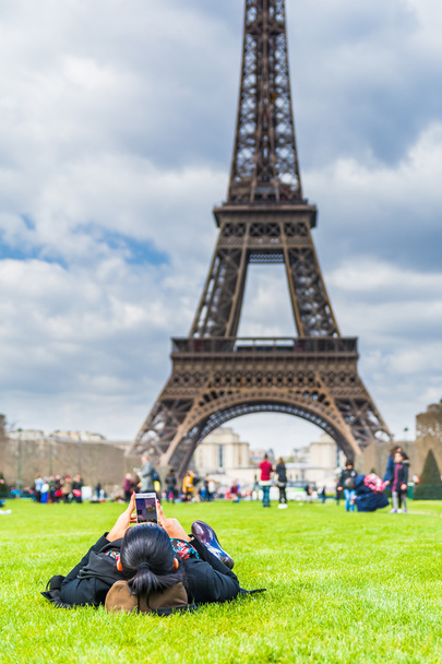 Jeune femme allongée sur le gras devant la tour Eiffel
 - Photo, image