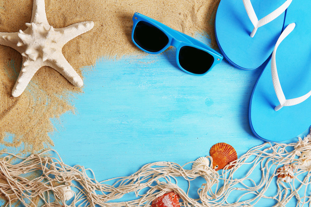 Flip Flops und Sonnenbrille mit Sand auf Holzgrund - Foto, Bild