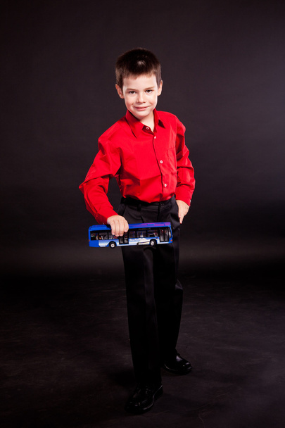 Boy in official dresscode with a toy bus - Photo, Image
