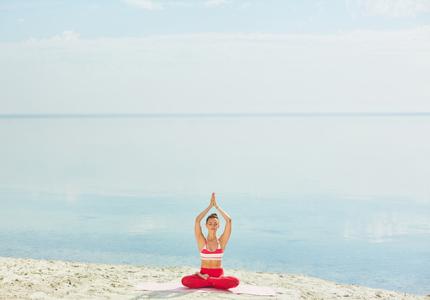 woman practicing yoga on beach - Photo, Image