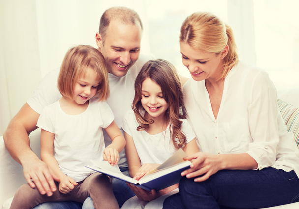 smiling family and two little girls with book - Fotografie, Obrázek