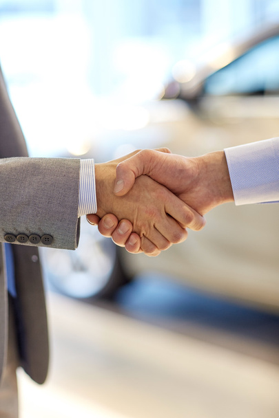close up of male handshake in auto show or salon - 写真・画像