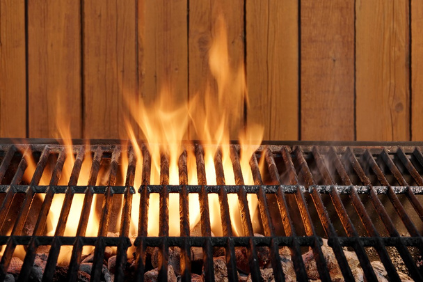 Lege vlammende houtskool Grill op de houten muur - Foto, afbeelding