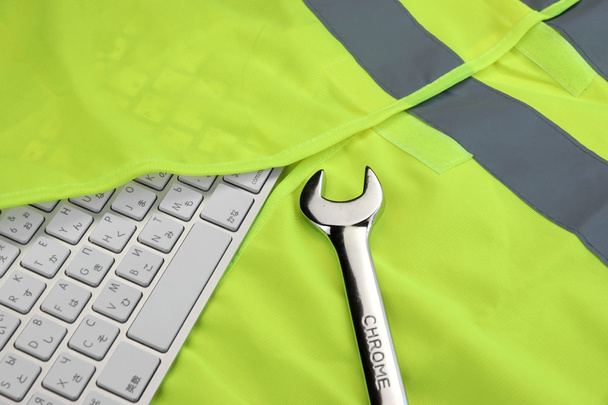 Keyboard In The Yellow Reflective Safety Vest And Wrench - Foto, afbeelding