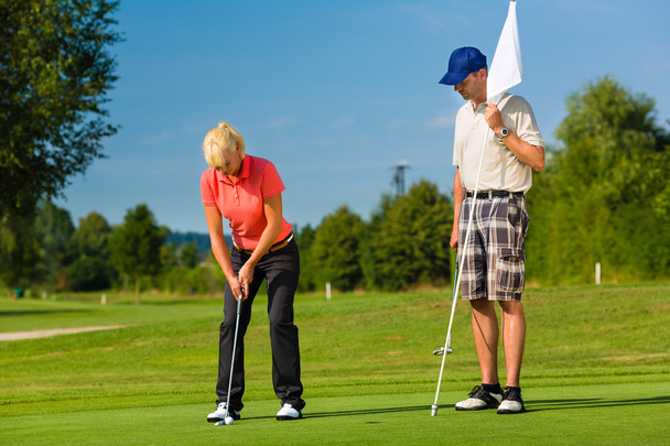 Молода спортивна пара грає в гольф на трасі
 - Фото, зображення