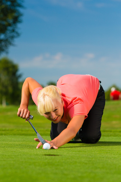 Jovem jogador de golfe do sexo feminino em curso com o objetivo de colocar
 - Foto, Imagem