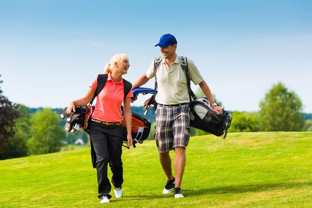Young sportive couple playing golf on a course - Photo, Image