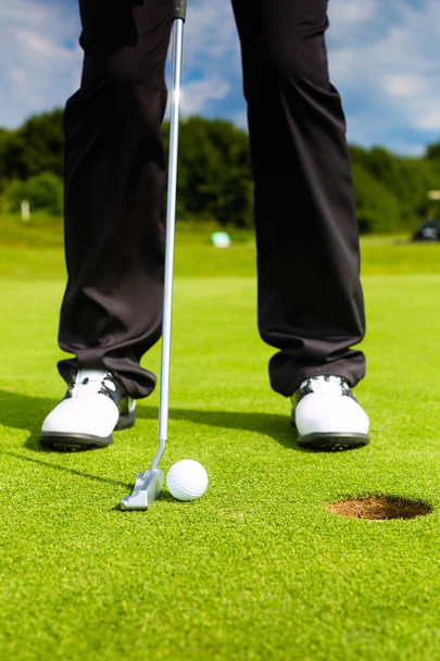 Jugador de golf poniendo pelota en el agujero
 - Foto, imagen